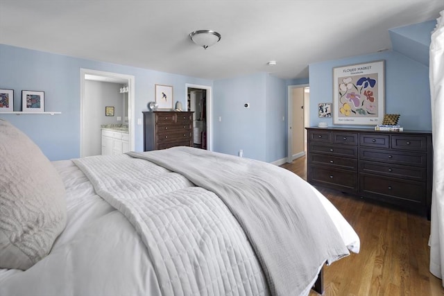 bedroom featuring connected bathroom and dark wood-style floors