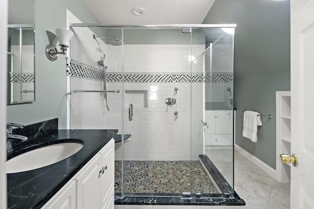 bathroom featuring a shower stall, baseboards, and vanity