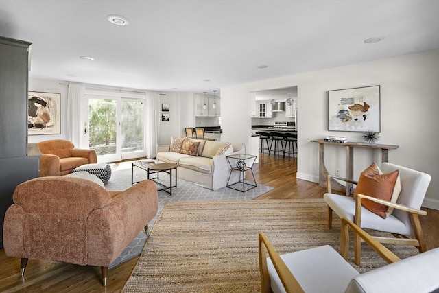 living area featuring baseboards, recessed lighting, and wood finished floors