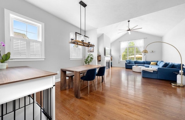 14 Dorset Park Ln, Weymouth, MA 02190 - dining space with light wood finished floors, ceiling fan, a fireplace, vaulted ceiling, and baseboards