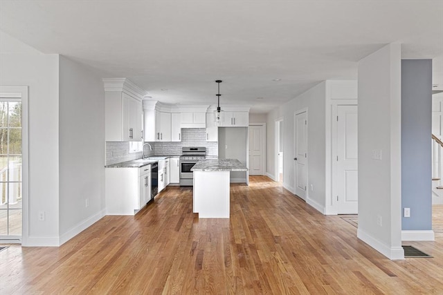 kitchen featuring tasteful backsplash, light wood-style floors, dishwasher, baseboards, and stainless steel range with gas stovetop