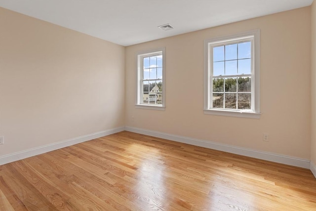 unfurnished room featuring visible vents, baseboards, and light wood-style floors
