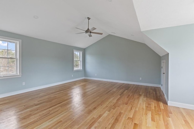 additional living space with lofted ceiling, plenty of natural light, light wood-style flooring, and ceiling fan