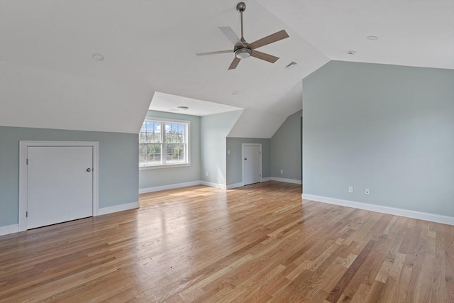 bonus room featuring lofted ceiling, visible vents, a ceiling fan, light wood-type flooring, and baseboards