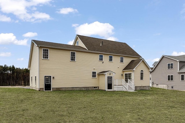 rear view of house featuring a yard