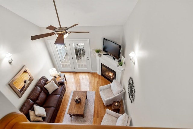 living room with ceiling fan, wood finished floors, and a glass covered fireplace