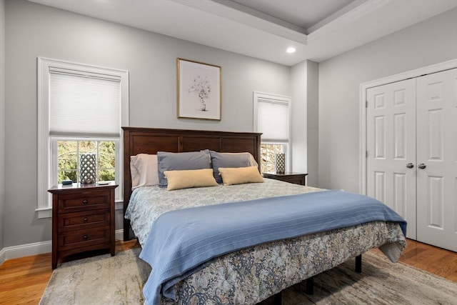 bedroom with recessed lighting, a closet, baseboards, and wood finished floors