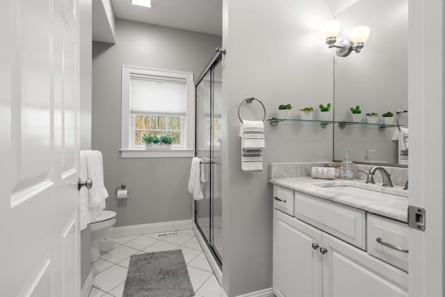 bathroom featuring tile patterned floors, vanity, a shower stall, and toilet