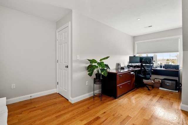 office area with visible vents, light wood-style floors, and baseboards