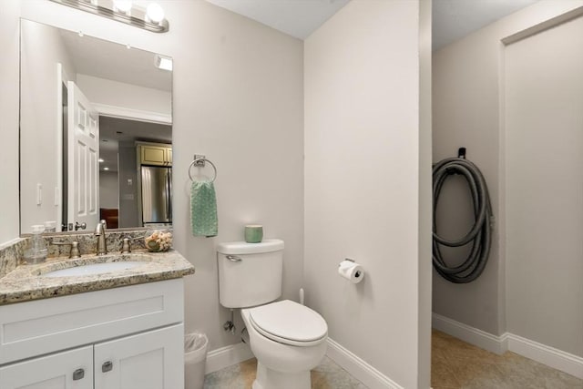 bathroom featuring tile patterned floors, toilet, vanity, and baseboards