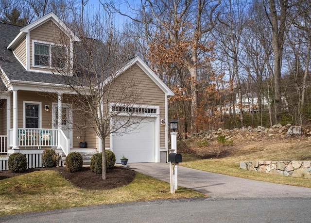 view of front of house with a porch, driveway, a garage, and roof with shingles