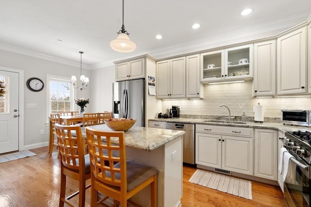 kitchen with a sink, stainless steel appliances, backsplash, and crown molding