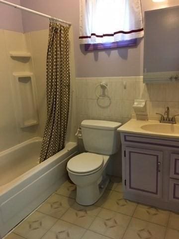 29 Conway St, Boston, MA 02131 - full bathroom featuring toilet, vanity, shower / tub combo, and a wainscoted wall