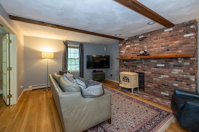 759 Main St, Boxford, MA 01921 - living area featuring beamed ceiling, light wood-style floors, a baseboard radiator, and a wood stove
