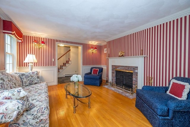 759 Main St, Boxford, MA 01921 - living room featuring stairs, wood finished floors, a baseboard heating unit, a brick fireplace, and wallpapered walls