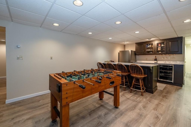 759 Main St, Boxford, MA 01921 - game room featuring beverage cooler, bar with sink, light wood finished floors, a paneled ceiling, and recessed lighting