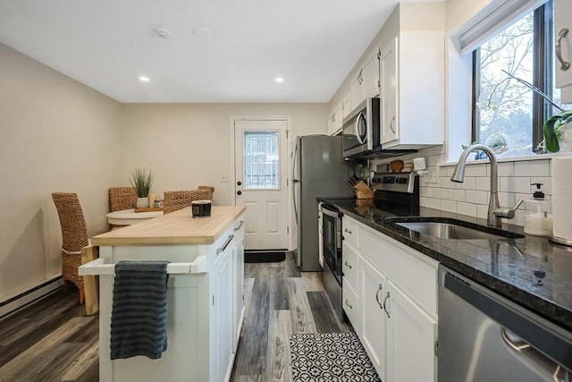 kitchen with tasteful backsplash, white cabinetry, sink, dark hardwood / wood-style flooring, and stainless steel appliances