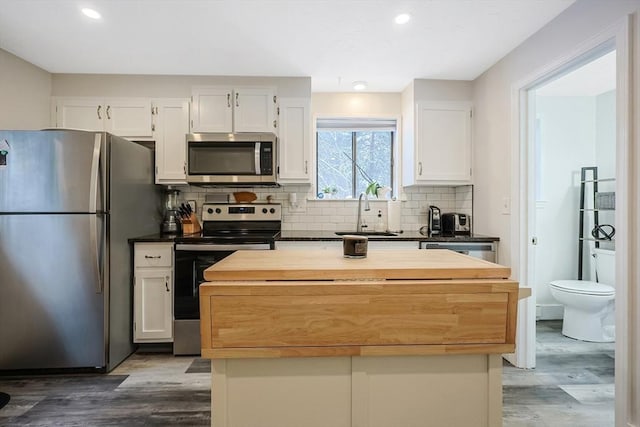 kitchen featuring sink, white cabinetry, appliances with stainless steel finishes, and tasteful backsplash