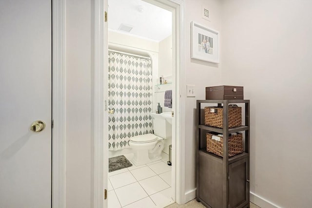 bathroom featuring toilet, curtained shower, and tile patterned flooring