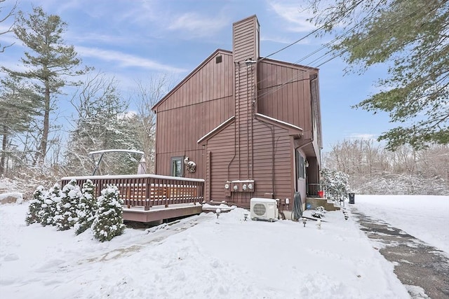 snow covered house featuring ac unit