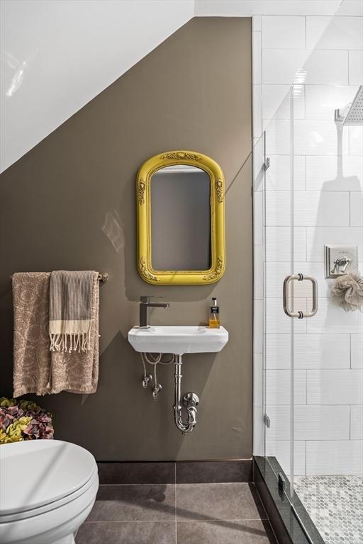 795 E 4th St, Boston, MA 02127 - bathroom featuring a shower stall, a sink, toilet, tile patterned floors, and baseboards