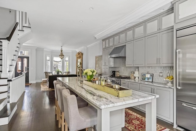 795 E 4th St, Boston, MA 02127 - kitchen featuring range hood, stainless steel appliances, gray cabinetry, dark wood-style flooring, and tasteful backsplash