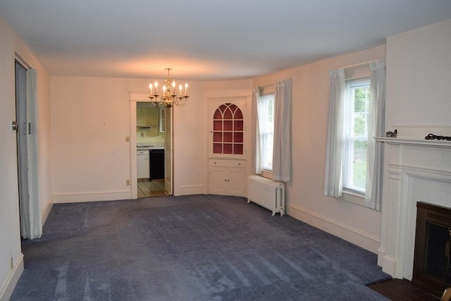959 Ray St, Fall River, MA 02720 - unfurnished living room with radiator heating unit, a chandelier, a fireplace with flush hearth, and dark colored carpet