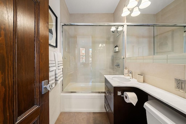 full bathroom featuring tile patterned floors, vanity, toilet, and enclosed tub / shower combo