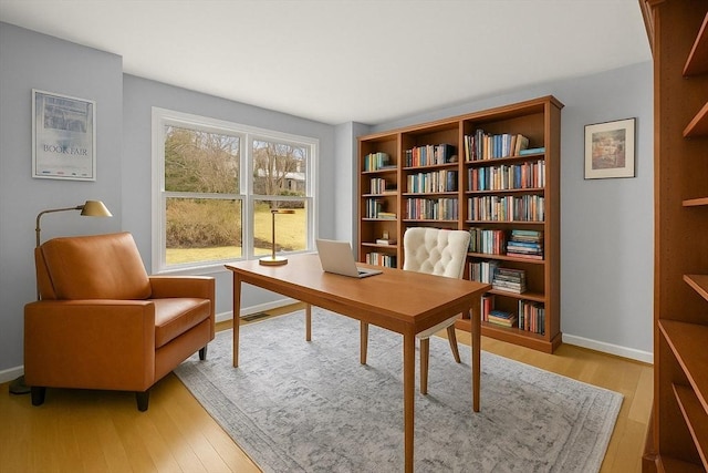 office featuring baseboards, visible vents, and light wood-style floors