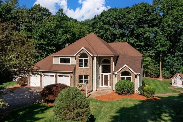 view of front facade featuring brick siding, a front lawn, and driveway