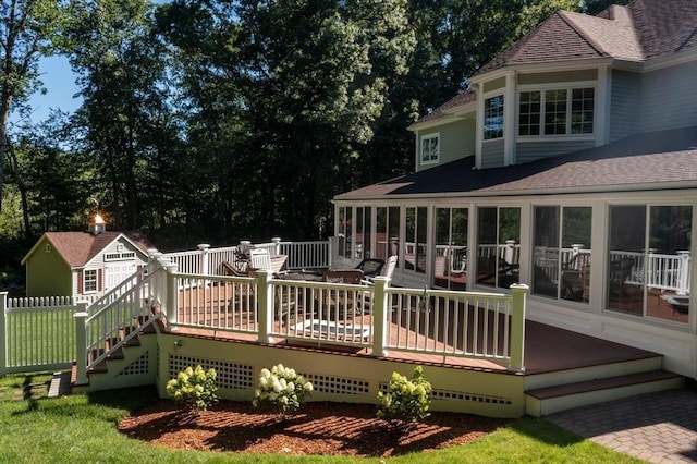 wooden deck with fence, an outdoor structure, and a sunroom