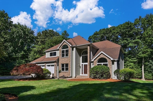 view of front of property featuring brick siding, a front yard, and a garage