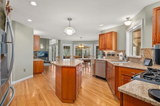kitchen with a sink, brown cabinetry, stainless steel appliances, and backsplash