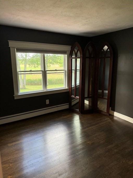 110 Atwell Cir, Marshfield, MA 02050 - unfurnished room with plenty of natural light, baseboards, a baseboard heating unit, dark wood-style flooring, and a textured ceiling