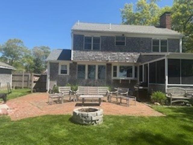 110 Atwell Cir, Marshfield, MA 02050 - back of property with a fire pit, a chimney, a patio area, and a sunroom