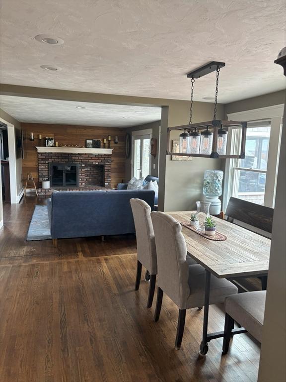 110 Atwell Cir, Marshfield, MA 02050 - dining area with dark wood-style flooring, a fireplace, and wooden walls