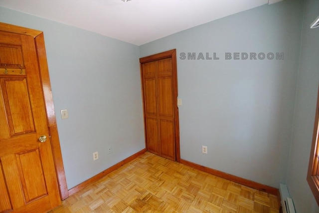 unfurnished room with baseboards and a baseboard radiator