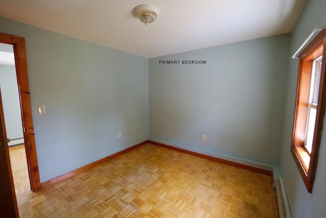 empty room featuring baseboards and a baseboard heating unit