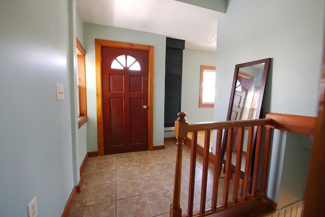 foyer entrance with baseboards and light tile patterned floors