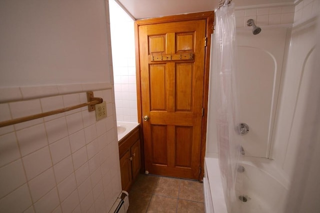 bathroom with tile walls, shower / bath combination with curtain, tile patterned flooring, and vanity
