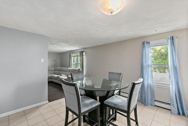 15 Crescent St Unit E, Lawrence, MA 01841 - dining space featuring plenty of natural light, baseboard heating, light tile patterned floors, a textured ceiling, and baseboards