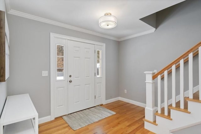 foyer entrance with crown molding and light hardwood / wood-style flooring