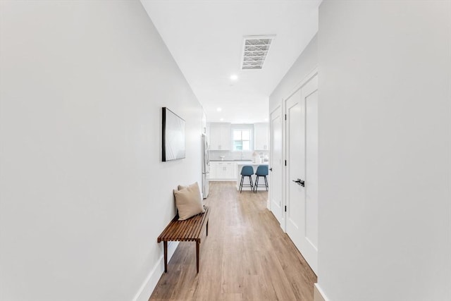 hall with baseboards, recessed lighting, visible vents, and light wood-style floors