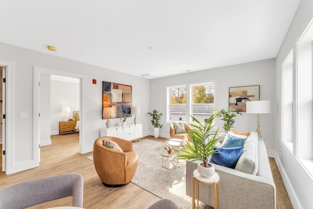 living area with light wood-style flooring and baseboards