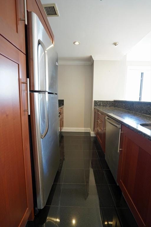 15 N Beacon St Unit 1006, Boston, MA 02134 - kitchen with stainless steel appliances, dark countertops, crown molding, baseboards, and dark tile patterned flooring