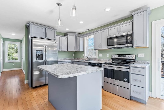 kitchen with light wood finished floors, appliances with stainless steel finishes, and gray cabinetry