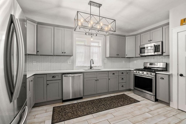 120 Fulton St, Lowell, MA 01850 - kitchen with stainless steel appliances, gray cabinets, a sink, and a chandelier