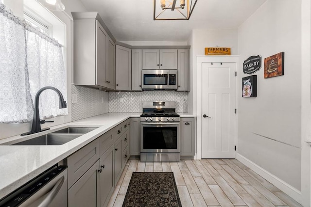 120 Fulton St, Lowell, MA 01850 - kitchen with stainless steel appliances, gray cabinets, a sink, and tasteful backsplash