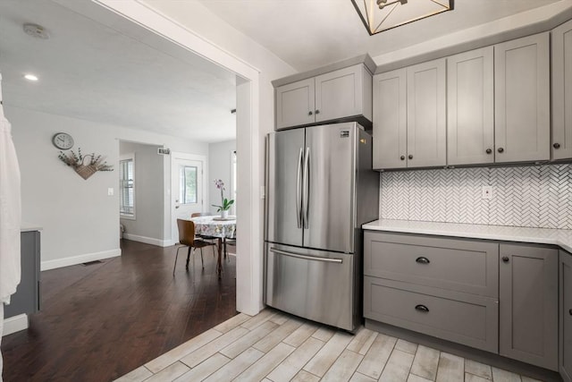 120 Fulton St, Lowell, MA 01850 - kitchen featuring freestanding refrigerator, gray cabinets, light wood finished floors, light countertops, and decorative backsplash