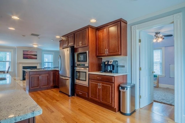 29 Carlton St Unit 2, Salem, MA 01970 - kitchen with appliances with stainless steel finishes, a peninsula, light wood finished floors, light stone counters, and recessed lighting